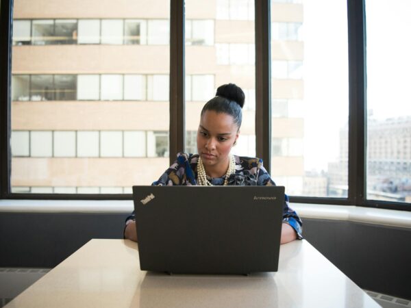 woman sitting on sofa facing lenovo thinkpad