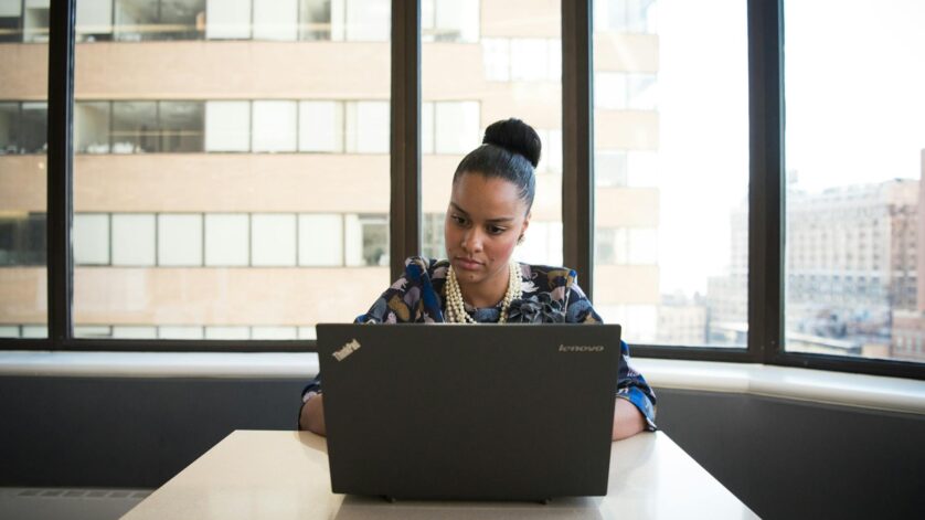 woman sitting on sofa facing lenovo thinkpad