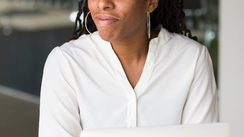 woman wearing white button up shirt sitting in front of table
