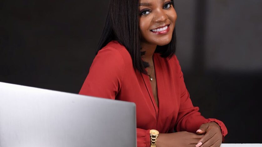 smiling woman sitting by desk with laptop