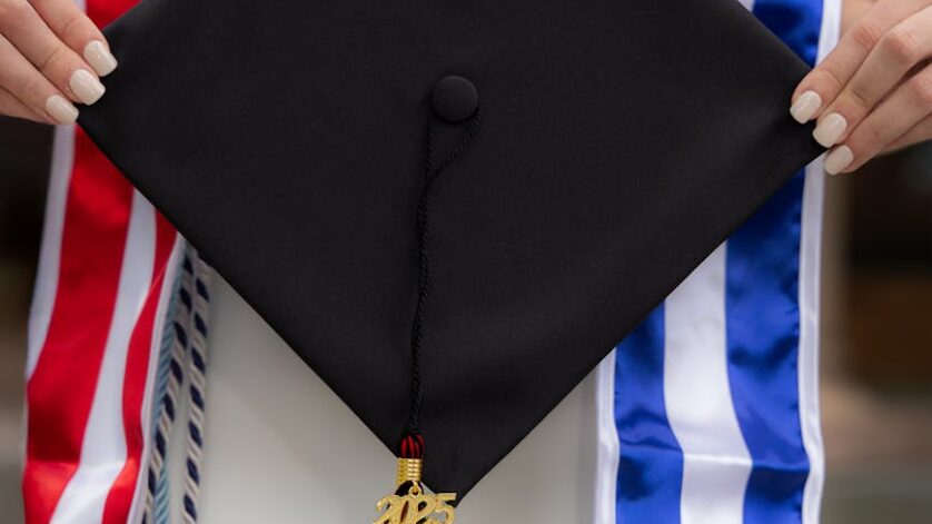 graduate holding cap with cuban and american flags