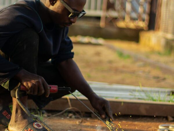 man welding outdoors on a sunny day