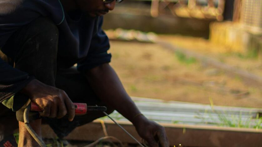 man welding outdoors on a sunny day