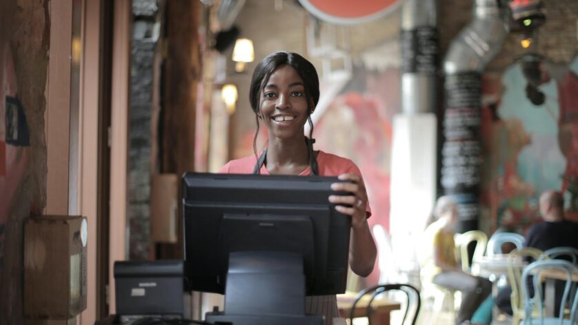 cheerful black waitress standing at counter