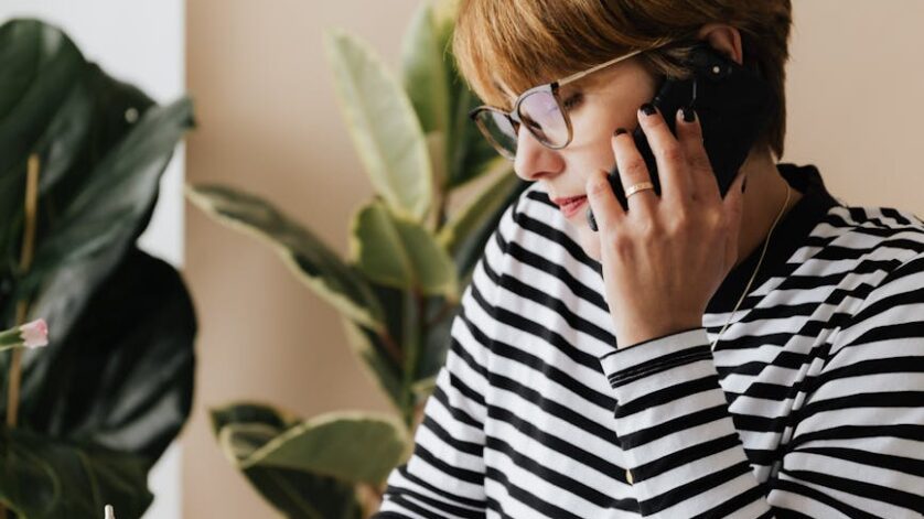 busy woman speaking on smartphone and writing notes