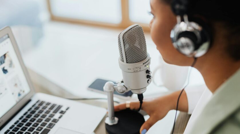 woman with headset speaking over a condenser microphone