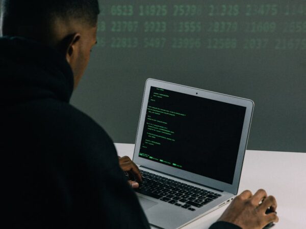 man in black hoodie using macbook air