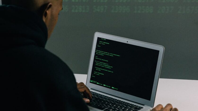 man in black hoodie using macbook air