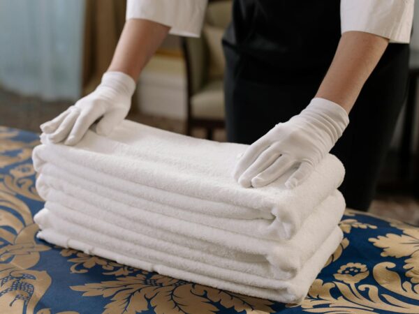 person holding a stack of white towels
