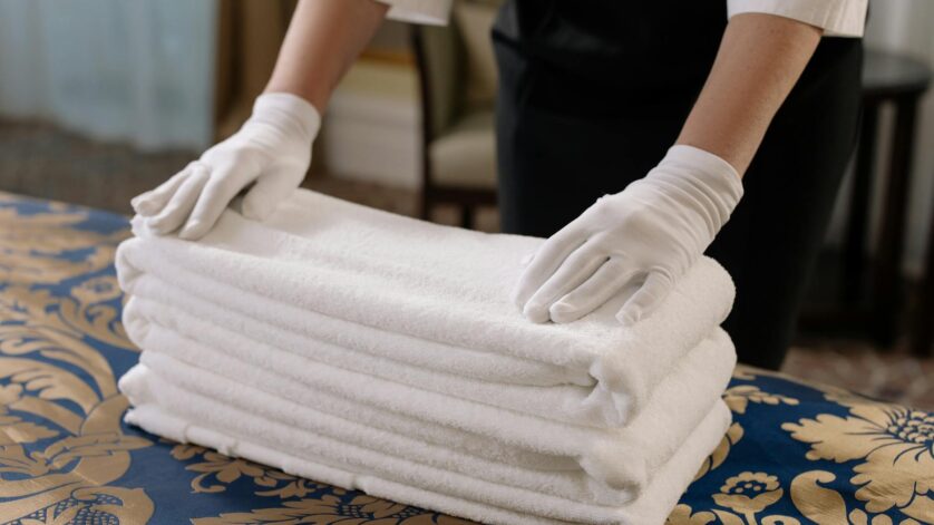 person holding a stack of white towels