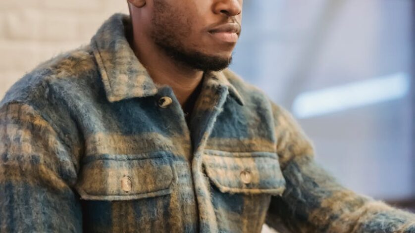 serious black man working on laptop at wooden table