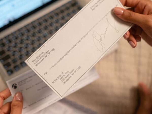 a person s hand holding a cheque