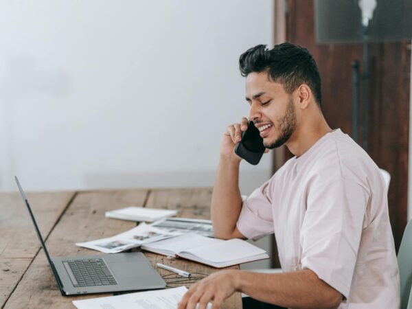 happy businessman speaking on phone at workplace