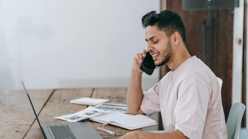 happy businessman speaking on phone at workplace