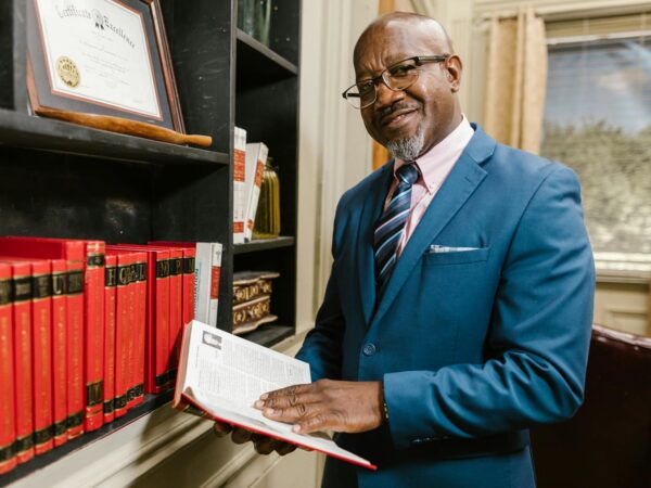 a man in blue suit jacket holding a book
