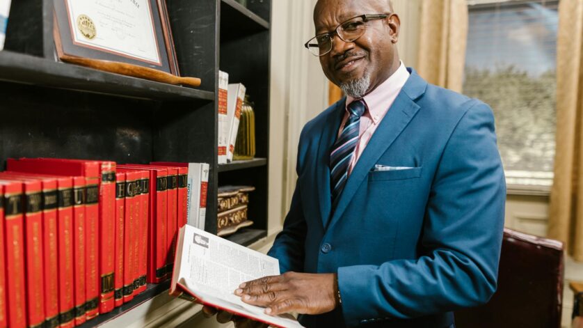 a man in blue suit jacket holding a book