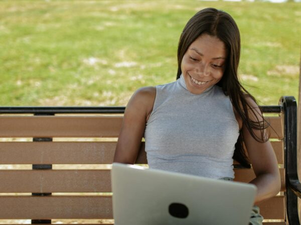 woman in gray shirt using a laptop
