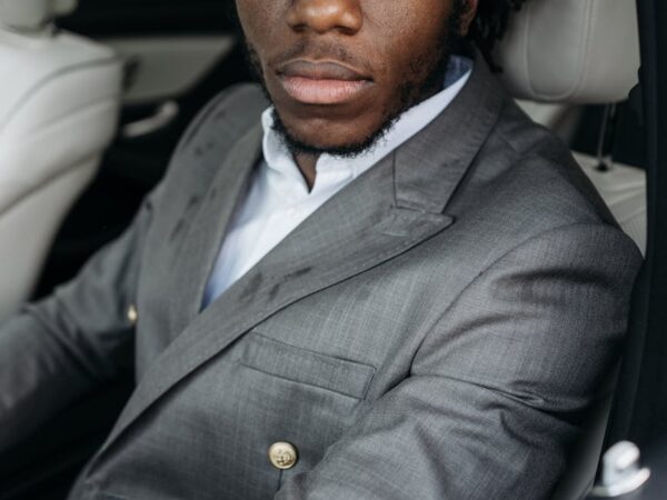 man in gray suit jacket sitting inside the car