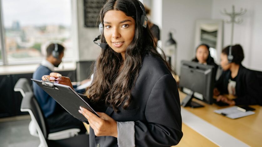 woman in black blazer holding a black clipboard and a pen
