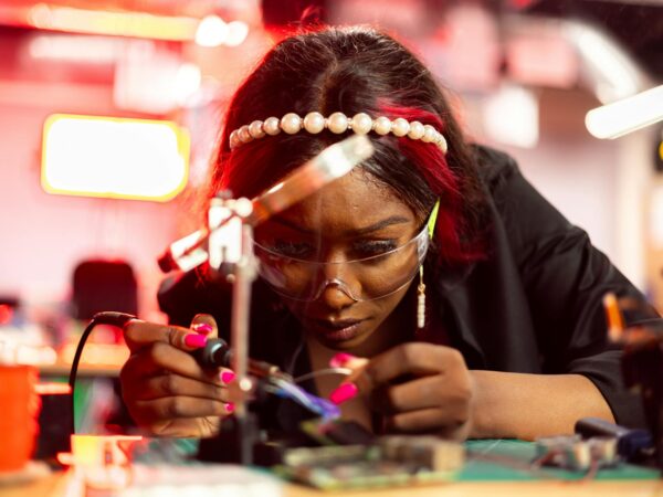 engineer using a soldering iron to fix an electronic equpiment