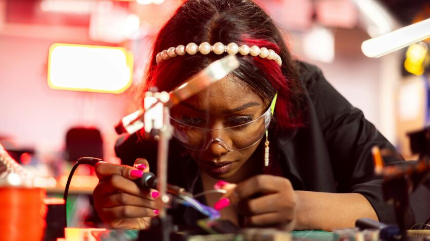 engineer using a soldering iron to fix an electronic equpiment