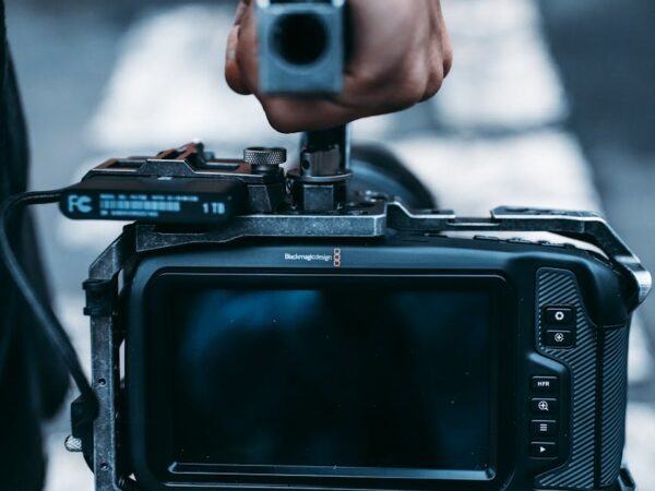 man carrying black video camera