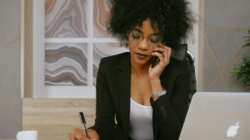 woman in black blazer holding smartphone