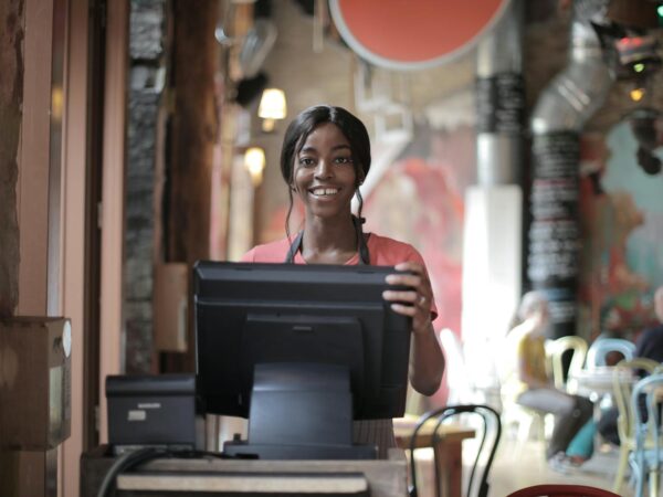 cheerful black waitress standing at counter
