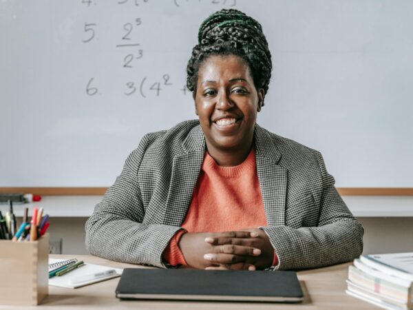 black cheerful woman smiling and sitting at table