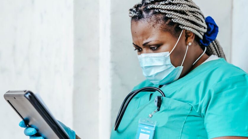 black physician in uniform with clipboard at work
