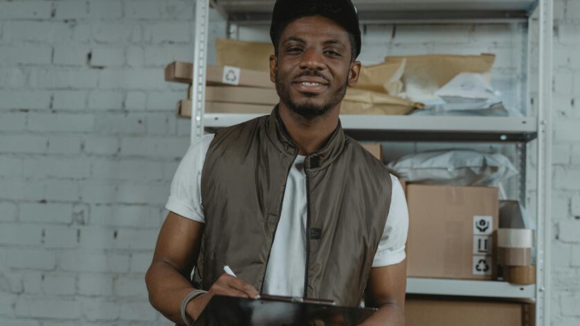 man in white button up shirt and black cap holding a clipboard