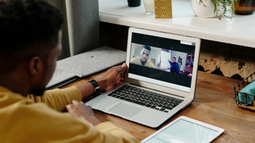 person in yellow long sleeve shirt using a laptop