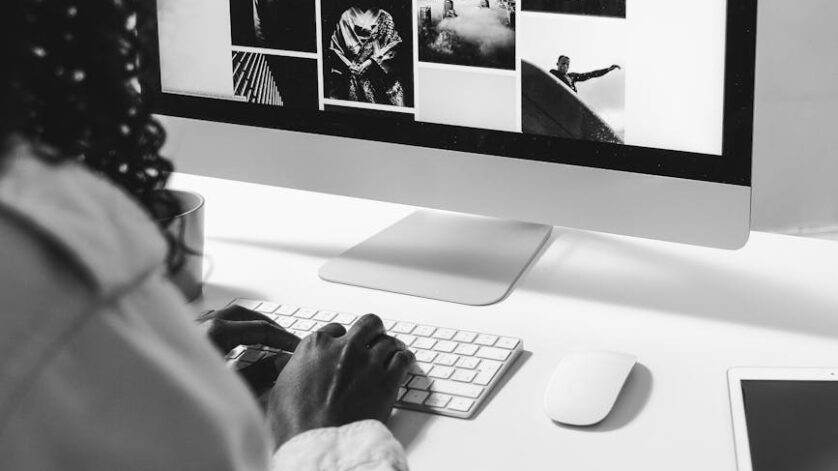 black woman typing on keyboard of modern computer
