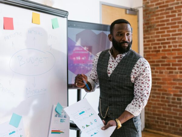 a man standing near the white board