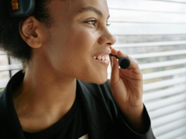 selective focus photo of a woman holding the microphone of her headset