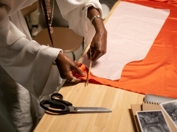 close up vew of fashion designer cutting fabrics