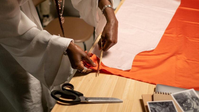 close up vew of fashion designer cutting fabrics