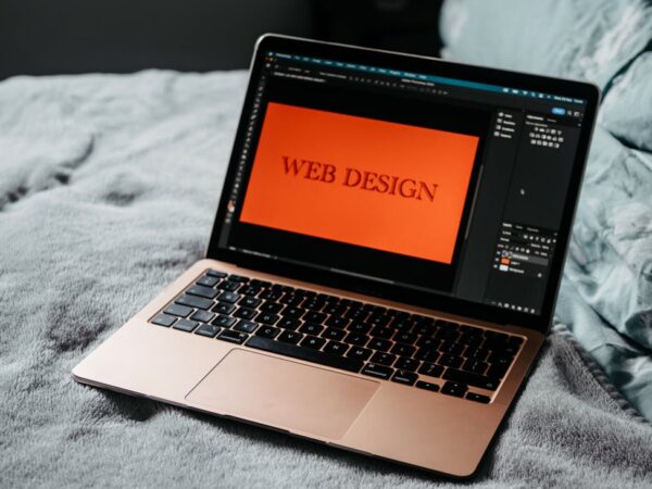 open laptop web design development on bed